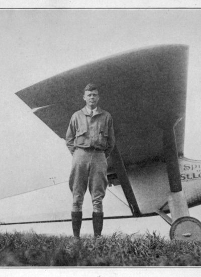 Charles Lindbergh standing beside the Spirit of St. Louis aircraft before his historic 1927 flight from Roosevelt Field on Long Island.
